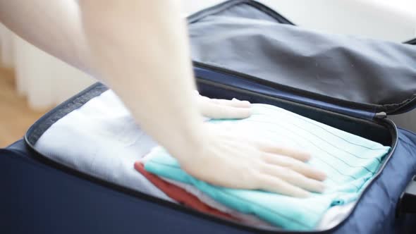 Close Up Of Man Packing Clothes Into Travel Bag 4