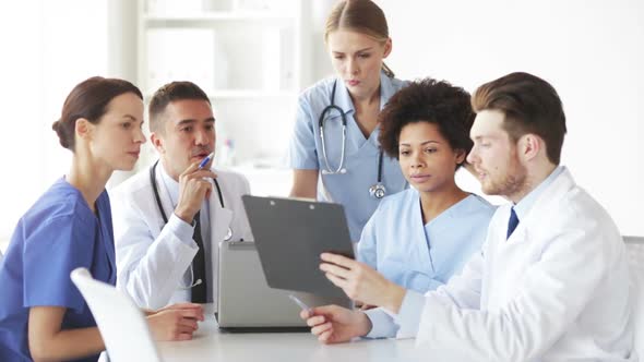 Group Of Doctors With Clipboard Talking At Clinic 1 alt