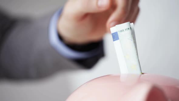Close Up Of Man Putting Money Into Piggy Bank 10 alt