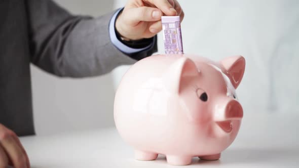 Close Up Of Man Putting Money Into Piggy Bank 13 alt