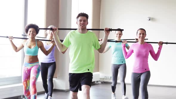 Group Of People Exercising With Bars In Gym 1
