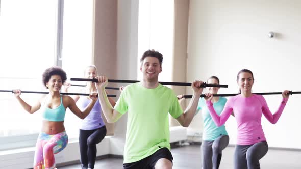 Group Of People Exercising With Bars In Gym 2