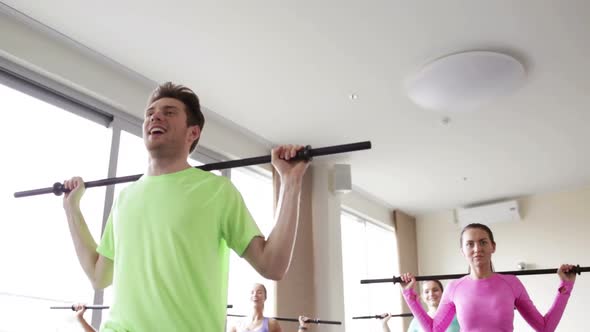 Group Of People Exercising With Bars In Gym 7