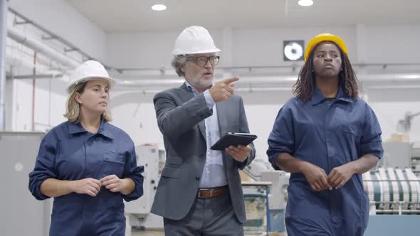 Senior Factory Owner and Two Diverse Female Workers