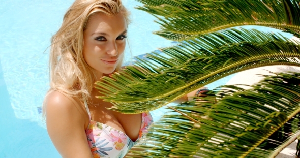 Pretty Woman In The Pool Holding Palm Leaves alt