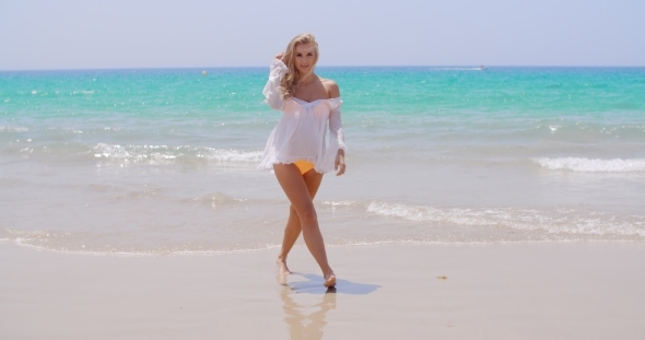 Pretty Young Woman Standing Against Ocean alt