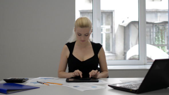 Businesswoman Typing on Tablet in Office