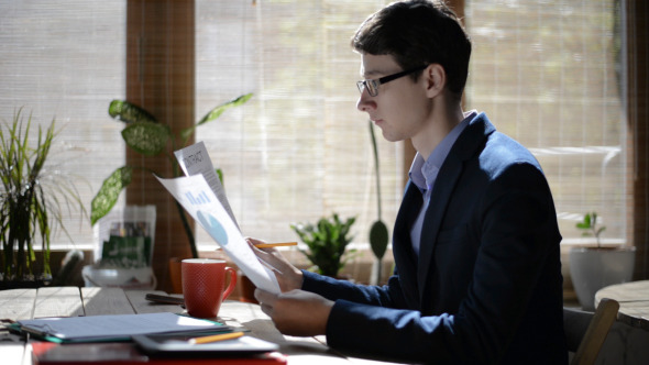 Young Man Drinking Coffee and Working