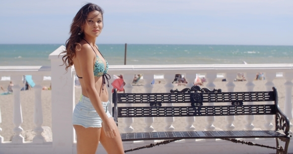 Sexy Young Woman Strolling Along a Promenade alt