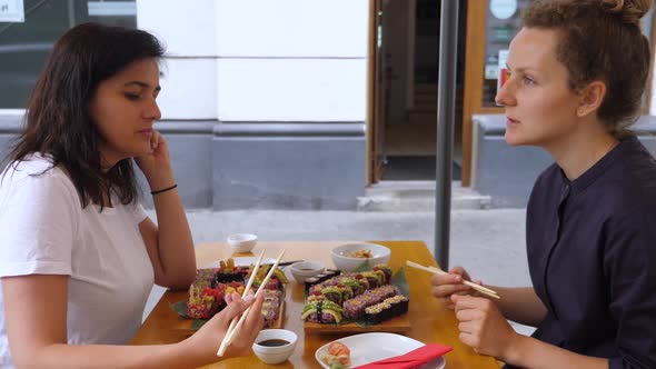 Two Girlfriends Chatting During Their Lunch at Japanese Restaurant. Female Friendship and Healthy