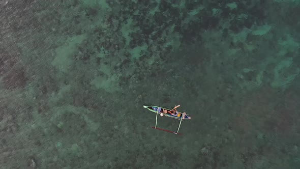 Aerial View Of A Fisherman Riding A Boat In Pink Beach Located In Indonesia Lombok - Aerial Shot