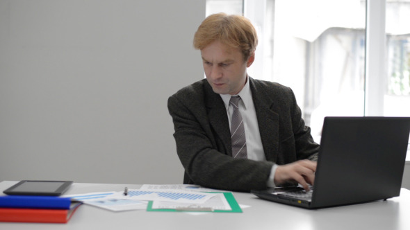 Businessman Working on Laptop in Office alt
