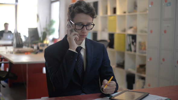 Young Man Busy on Phone in Office alt