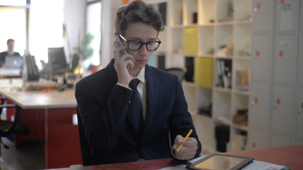 Young Man Busy on Phone in Office