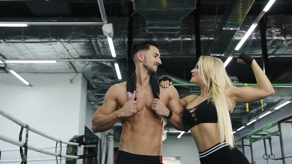 Attractive Sport Couple Man and Woman Possing on the Gym Background