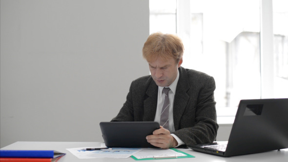 Businessman in Hurry Using Tablet at Work