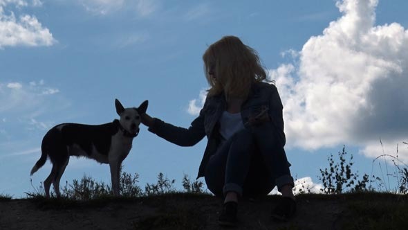 Girl and Dog on the Background of Sky