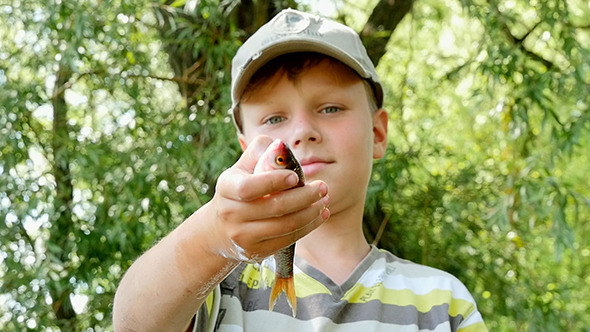 Boy Holding A Fish In His Hand alt