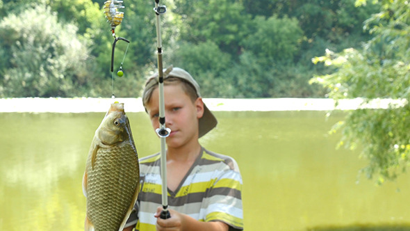 Young Caucasian Boy With Fishing Pole And Fish
