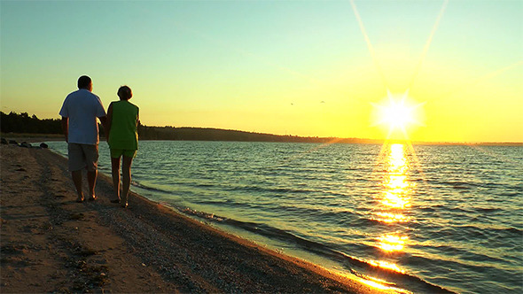 Couple Are on the Beach Against the Backdrop Sun