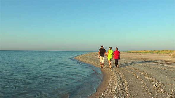 Mother and Child Walk Along the Seashore at Dawn