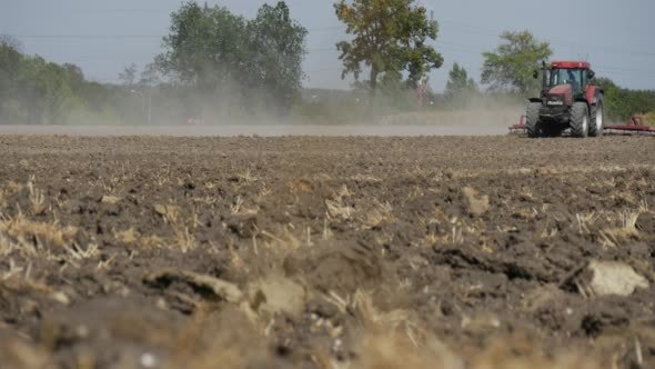 Tractor is Plowing Field Soil Driver's Silhouette