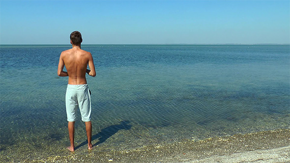 The Guy is on the Beach and Throwing Stones 