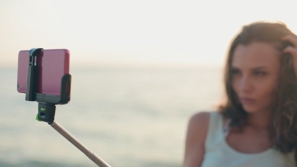 Attractive Girl Standing In The Sea With a Monopod
