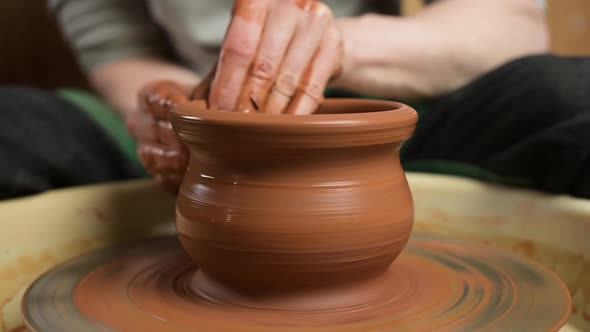 process of making a clay pot by a potter, close-up. A potter creates a clay pot