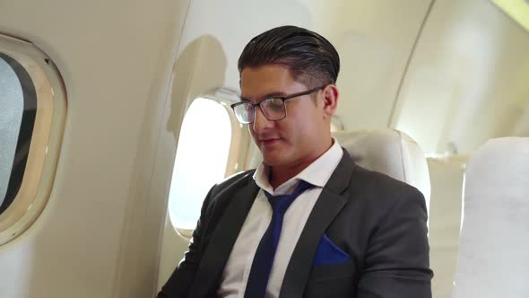 Young Businessman Using Laptop Computer in Airplane