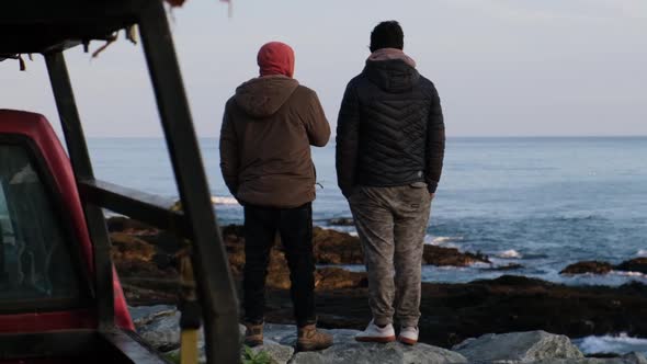 Slow motion: friends look at the sea and chat as they prepare to go fishing and spearfishing during