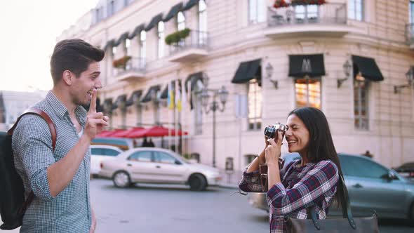 Young Mixed Race Tourist Couple Taking Pictures on Vintage Camera While Walking Through the City