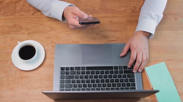 Businessman freelancer working at home office, using the smartphone in a hand