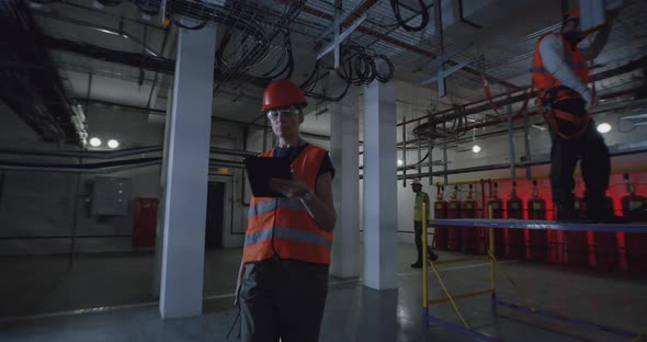 Female Inspector with Tablet Walking in Workshop