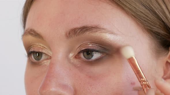 Beautiful Shiny Shadows are Applied with a Special Brush on the Eyelid of the Model
