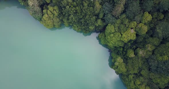 Aerial 4K drone video of a tropical hidden lake surrounded by trees in Sao Miguel, Azores islands.