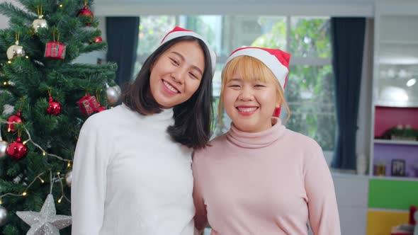 Asian Lesbian couple celebrate relax happy smiling looking at camera enjoy xmas winter holidays.