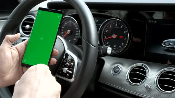 Man Hold Smartphone in Car on Dashboard Background