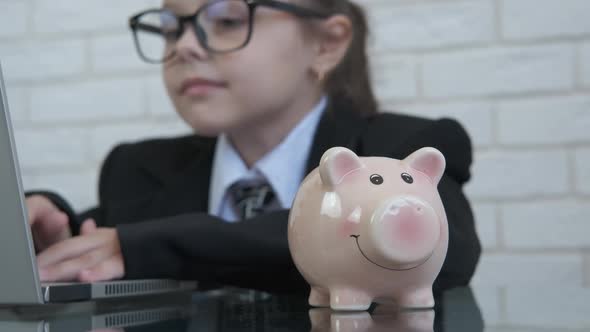 Little businessman with a piggy bank.