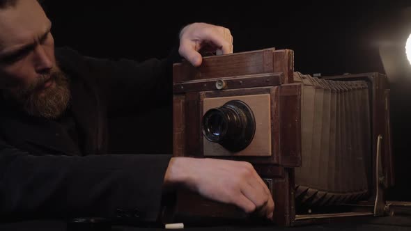 Active Bearded Man Carefully with Smile and Enthusiasm Restore Old Vintage Retro Camera, Clean Lens