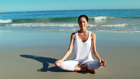 Woman performing yoga at beach