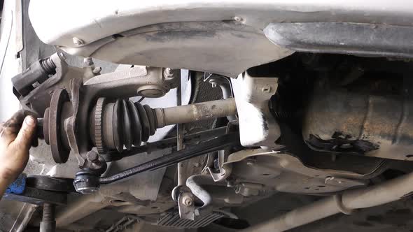 Mechanic Repairs Car Axle Undercarriage