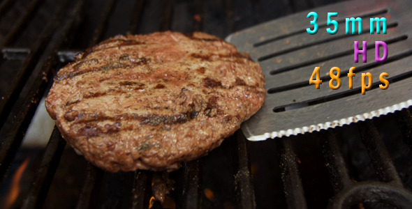 Flipping A Hamburger On The Grill