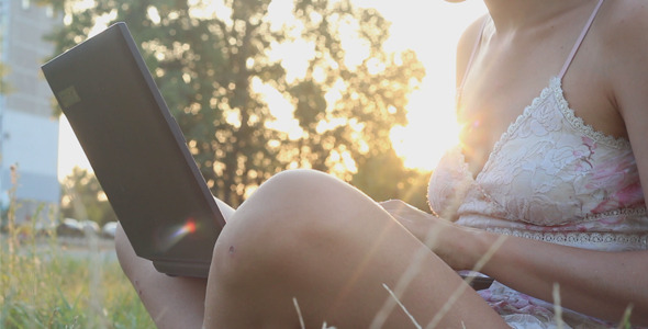 Girl on a Lawn and Using Laptop at Sunset alt