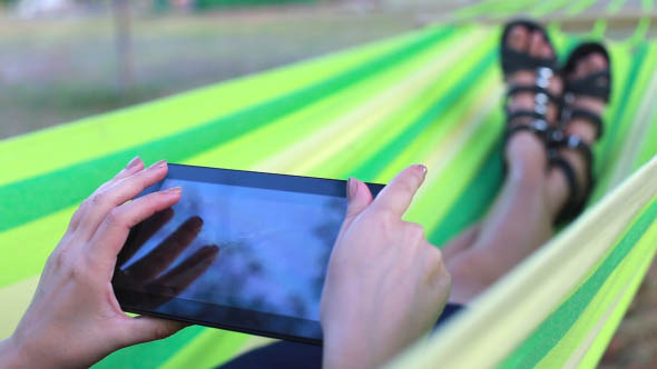 Woman Looks Pictures on the Tablet alt