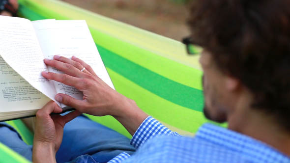 Man Reading a Book in a Hammock