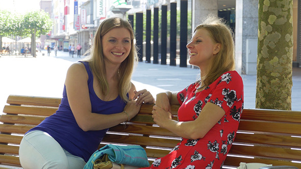 Two Beautiful Young Woman Resting On A Bench