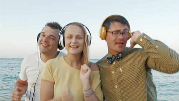 Excited Trio Enjoying Music In Headphones Outdoor alt