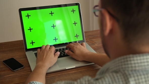 Man Working With Laptop Placed On Wooden Desk alt