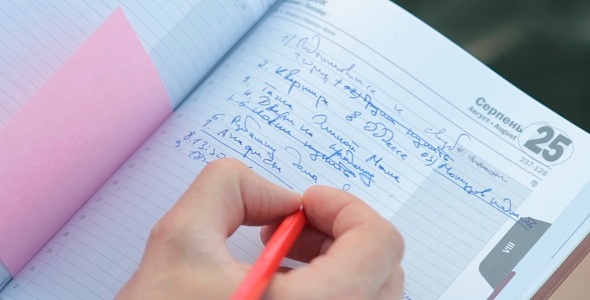 Man Writes In Notebook